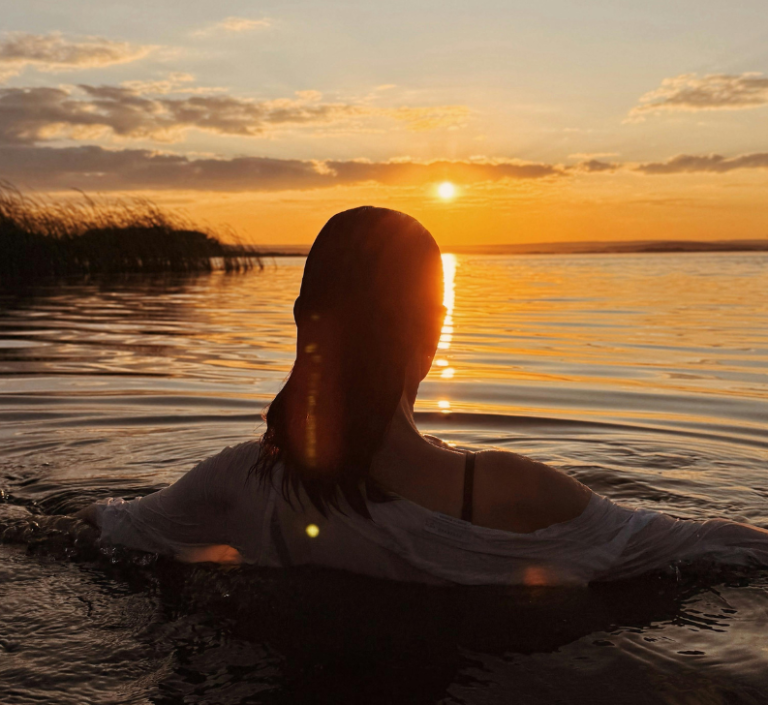 Swimmer enjoying a peaceful sunset dip during an evening wild swimming session in Stirlingshire